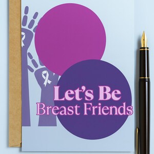 以下が含まれることがあります： ピンク色の「Let's Be Breast Friends」という文字が入ったグリーティングカード。紫色の円が2つと茶色の封筒があります。右側には、金のペン先が付いた黒い万年筆があります。