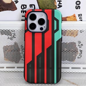 May include: A smartphone case with a geometric design. The case features vertical stripes in red, black, and teal. The case has a black border around the camera and the phone's edge.