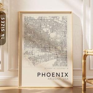 May include: A framed wall art print featuring a detailed black and white street map of Phoenix, Arizona. The map includes the coordinates 33.4484 N | 112.0740 W, with the text PHOENIX ARIZONA, USA printed in bold black letters at the bottom.