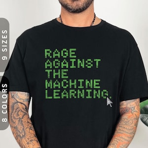 Könnte beinhalten: Schwarzes T-Shirt mit dem grünen Text "RAGE AGAINST THE MACHINE LEARNING" in pixeliger Schrift. Am Ende des Textes befindet sich ein weißer Cursor. Das T-Shirt wird von einer Person getragen.