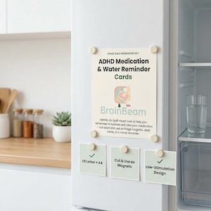 May include: A set of printable ADHD medication and water reminder cards attached to a white refrigerator with round magnets. The main card features the text BrainBeam and instructions for use, while three smaller cards list features like US Letter + A4.