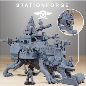 May include: A grey resin miniature of a large, armored creature carrying a heavy weapon platform with multiple cannons and spikes. The creature features a mechanical jaw and is accompanied by a smaller humanoid figure standing in front.