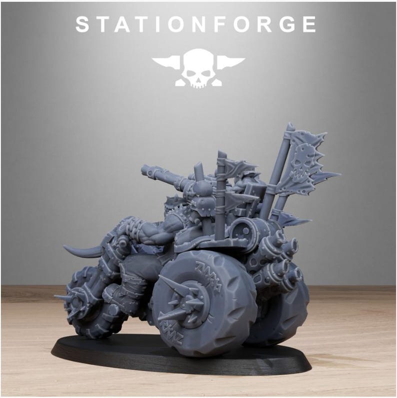 Puede incluir: Modelo en miniatura gris de una motocicleta fuertemente armada con grandes ruedas con p&uacute;as. El modelo presenta un dise&ntilde;o detallado con un emblema de calavera y el texto "STATIONFORGE" en la parte superior.