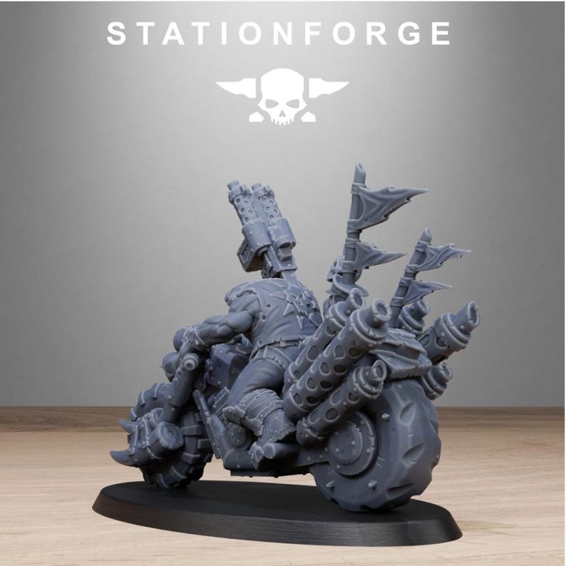 Puede incluir: Una motocicleta en miniatura gris con un piloto, con grandes tubos de escape, banderas y un arma montada. La motocicleta est&aacute; sobre una base negra, con el texto "STATIONFORGE" y un logotipo de calavera encima.