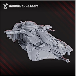 Op de afbeelding: Een grijs, futuristisch ruimteschipmodel met ingewikkelde details, waaronder meerdere geschutskoepels en een centrale koepel. De afbeelding toont de tekst "DakkaDakka.Store". Het ontwerp suggereert een sciencefiction- of gamingthema.