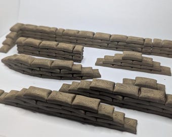 May include: A collection of miniature sandbag walls in various shapes and sizes. The sandbags are a muted brown color, arranged to create defensive structures. Ideal for tabletop gaming or model building.