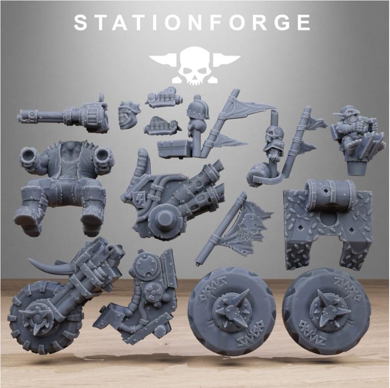 Puede incluir: Un conjunto de piezas de modelo en miniatura grises, que incluyen un chasis de motocicleta, ruedas y varios componentes de armas. Las piezas presentan dise&ntilde;os mec&aacute;nicos y con tem&aacute;tica de calaveras. El texto "STATIONFORGE" est&aacute; en la parte superior.