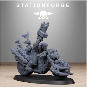 Puede incluir: Una figura en miniatura gris de un personaje montado en una motocicleta, con neum&aacute;ticos grandes y un arma montada en la parte delantera. La figura tiene un logotipo de calavera y huesos cruzados encima, con el texto "STATIONFORGE".