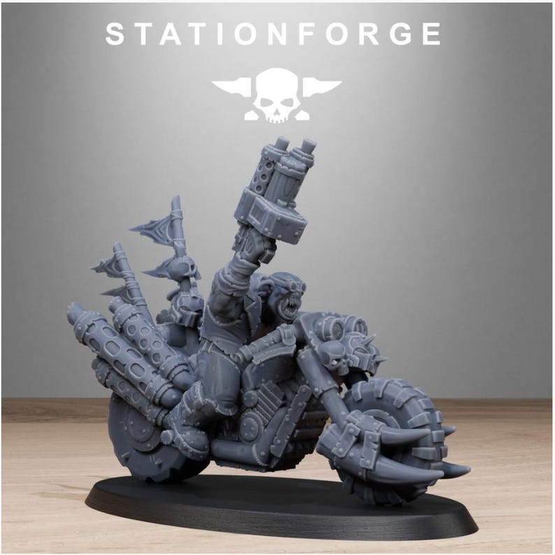Puede incluir: Una figura en miniatura gris de un personaje montado en una motocicleta, con neum&aacute;ticos grandes y un arma montada en la parte delantera. La figura tiene un logotipo de calavera y huesos cruzados encima, con el texto "STATIONFORGE".