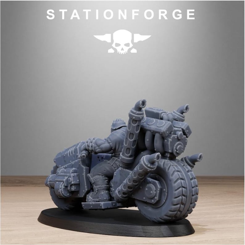 Puede incluir: Una miniatura de motocicleta gris con un dise&ntilde;o detallado, con neum&aacute;ticos grandes y tubos de escape. El texto "STATIONFORGE" se muestra encima de la motocicleta, junto con un logotipo de calavera y alas. La motocicleta est&aacute; sobre una base negra.