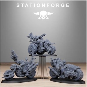 Puede incluir: Tres motocicletas grises en miniatura con dise&ntilde;os mec&aacute;nicos detallados. Las motocicletas tienen ruedas grandes y puntiagudas, armas montadas y figuras en el asiento del conductor. La palabra "STATIONFORGE" est&aacute; impresa en la parte superior de la imagen.