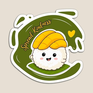 May include: A magnet featuring a cute sushi character with a smiling face and yellow mango topping. The sushi is on a green leaf, surrounded by a green shape with the words "Spread Kindness" in gold script and a yellow heart.