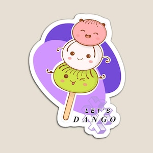 Może przedstawiać: Magnes z trzema kreskówkowymi dango, japońskim przysmakiem, z uśmiechniętymi twarzami. Dango są różowe, białe i zielone, na drewnianym patyku. Tekst "LET'S DANGO" jest również dołączony.