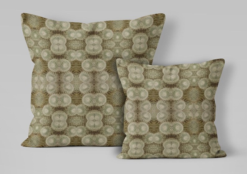 Puede incluir: Dos cojines decorativos con un patr&oacute;n repetitivo de formas beige y marr&oacute;n. El patr&oacute;n crea un dise&ntilde;o sim&eacute;trico en las superficies de los cojines. Los cojines son de diferentes tama&ntilde;os.