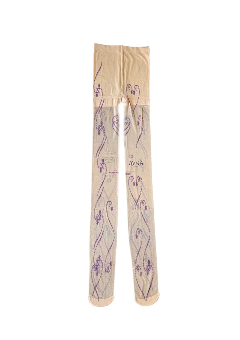 May include: Sheer beige tights with a repeating purple heart and swirl pattern. The tights have a reinforced toe and a label with the number 13 and a small graphic. A stylish and unique fashion accessory.