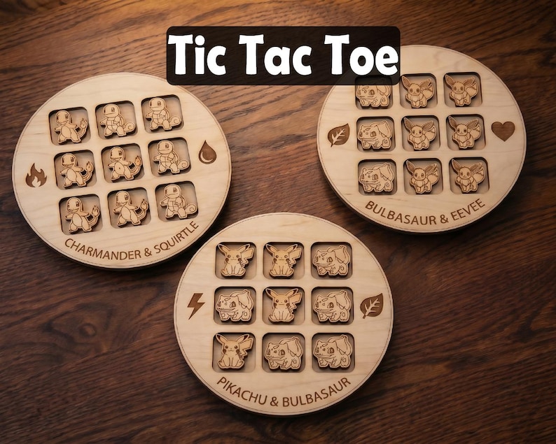 May include: Three circular wooden tic tac toe boards featuring engraved character designs. One board shows Charmander and Squirtle, another Bulbasaur and Eevee, and the third Pikachu and Bulbasaur. Each board includes elemental icons and text labels.