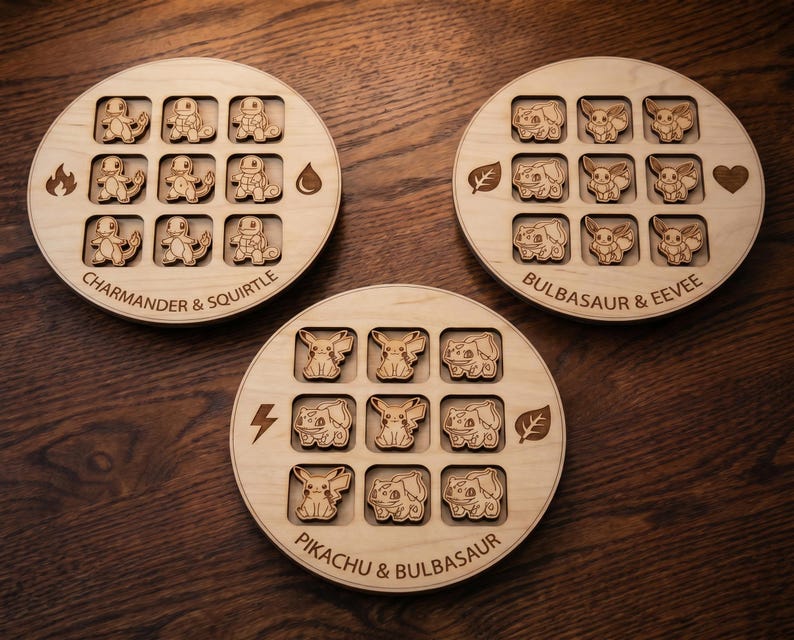 May include: Three circular light-coloured wooden tic-tac-toe boards featuring laser-engraved character designs. Each board has a 3x3 grid with wooden game pieces depicting various creatures, along with engraved text and symbols like fire, water, leaf, and heart.