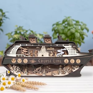 Puede incluir: Maqueta de barco de crucero de madera con exterior gris oscuro e interiores marrón claro. El modelo presenta diseños recortados de personajes, un castillo y las palabras "CRUISE LINE". Elementos decorativos: barco hundido y vida marina.