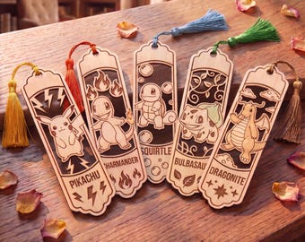 Puede incluir: Cinco marcapáginas rectangulares de madera con diseños cortados a láser de Pikachu, Charmander, Squirtle, Bulbasaur y Dragonite. Cada marcapáginas incluye una borla de color y nombres de personajes, rayos, llamas, burbujas, hojas y estrellas grabados.