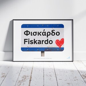 May include: Framed print featuring a road sign design. The sign reads "Fiskardo" in both Greek and English, with a red heart graphic. The sign has a blue border and is mounted on a white background.