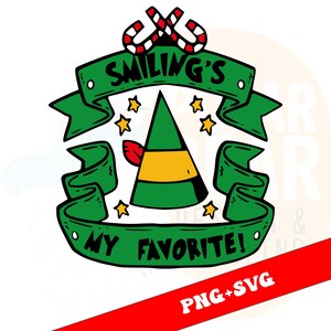 Op de afbeelding: Een groene elfenmuts met een gele band en een rode veer is gecentreerd in een ontwerp met de tekst "Smiling's My Favorite!" op een groene banner. Het ontwerp bevat gele sterren en zuurstokken.