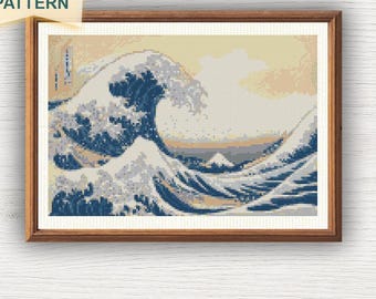 May include: A framed cross-stitch pattern depicting Hokusai's "The Great Wave off Kanagawa." The image shows a large wave in blue and white, with a mountain in the distance. The text "CROSS STITCH PDF PATTERN" is on a yellow sticky note.