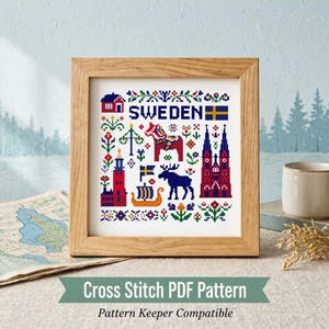 May include: A square cross stitch pattern in a light wood frame featuring the word SWEDEN in blue, a red Dala horse, a blue moose, a yellow Viking ship, a red church, a red house, a Swedish flag, and various colourful floral motifs on white.