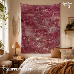 Puede incluir: Un tapiz de pared rectangular grande con un patrón floral abstracto en tonos magenta profundo y burdeos con sutiles reflejos blancos. La tela muestra un diseño texturizado similar a la acuarela con motivos botánicos dispersos.