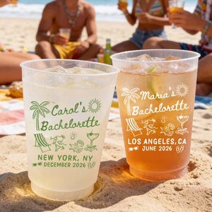 May include: Two clear plastic cups filled with beverages. The left cup features green text reading Carol's Bachelorette, New York, NY, December 2026, with palm tree, beach chair, and cocktail icons. The right cup has white text reading Maria's Bachelorette, Los Angeles, CA, June 2026.
