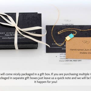 May include: A gold necklace with a turquoise and gold rectangular pendant. The necklace is packaged in a black box with a white ribbon. The box has the text "Elegant Jewelry" on it. The necklace comes with a card that says "Handcrafted Just for you with endless love!"