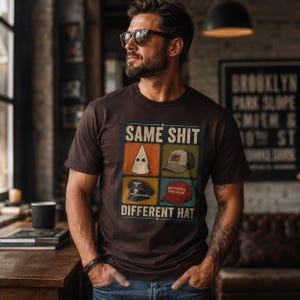 Puede incluir: Una camiseta de manga corta de color marrón oscuro con un estampado gráfico que incluye el texto SAME SHIT DIFFERENT HAT. El diseño presenta cuatro paneles cuadrados que muestran una capucha blanca, una gorra estampada, una gorra militar y una gorra roja.