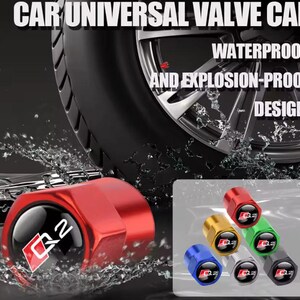Könnte beinhalten: Rote universelle Ventilkappe für Autos mit dem Text "Q2" und einem Logo. Das Bild zeigt auch einen Reifen und den Text "WATERPROOF AND EXPLOSION-PROOF DESIGN". Zusätzliche Ventilkappen in Gold, Grün, Blau, Silber und Schwarz sind ebenfalls abgebildet.