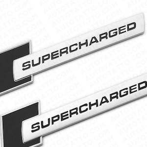 Könnte beinhalten: Zwei silberfarbene "SUPERCHARGED" Autoembleme mit schwarzem Text. Jedes Emblem hat eine rechteckige Form mit einem schwarzen Quadrat auf der linken Seite. Der Hintergrund ist weiß.