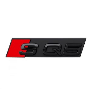 Peut inclure: Emblème SQ5 noir et rouge. L'emblème présente les lettres "SQ5" en noir, avec un accent rouge sur le côté gauche. De forme rectangulaire, il présente une finition brillante.