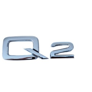 Peut inclure: Emblème Q2 chromé brillant. Les lettres sont dans une police moderne, le Q présentant un contour carré et une barre oblique. Le chiffre 2 est un chiffre stylisé. L'emblème est conçu pour l'automobile.