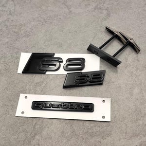 Könnte beinhalten: Schwarze S8- und Quattro-Autoembleme und ein Paar schwarze Manschettenknöpfe. Die S8-Embleme sind in glänzend schwarzer Ausführung, mit einem größeren und einem kleineren Emblem. Das Quattro-Emblem ist ebenfalls schwarz.