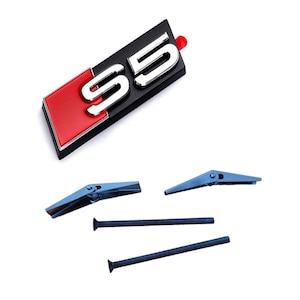 May include: A black and red S5 emblem with silver lettering and mounting hardware. The emblem has a red accent and a small red tab. Also included are two blue metal clips and two blue screws.