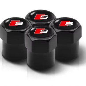 Könnte beinhalten: Vier schwarze, sechseckige Reifenventilkappen mit einem rot-weißen "S"-Logo. Die Kappen haben eine glänzende Oberfläche und sind für den Automobilbereich konzipiert.