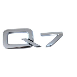 Peut inclure: Emblème chromé "Q7", probablement pour un véhicule. Le "Q" est une forme carrée avec un trait diagonal, et le "7" est un chiffre stylisé. L'emblème a une finition brillante et réfléchissante.