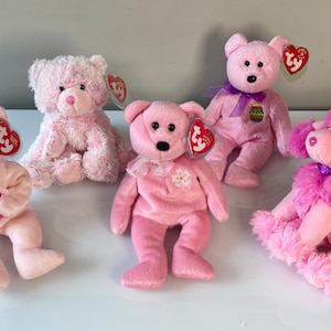 May include: A collection of five pink plush toys including four teddy bears and one poodle. Each toy features a red heart-shaped Ty tag attached to the ear. The bears have various pink shades, ribbons, and small decorative accents, while the poodle has curly fur.