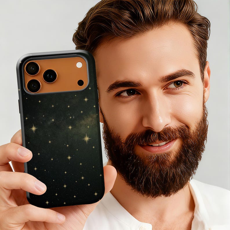 May include: A black smartphone case with a dark green and gold starry night design. The case has a black border and a brown camera section. The phone case is held in a person's hand.