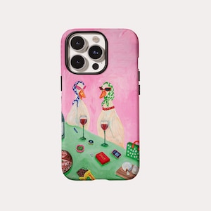 May include: Pink iPhone case with a quirky illustration of two ducks at a table. The ducks are adorned with headscarves and sunglasses, with wine glasses and snacks on the table. The word "SASSY" is visible on a red box.