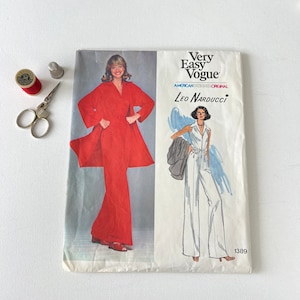 May include: A vintage Very Easy Vogue sewing pattern by Leo Narducci, featuring a red jumpsuit and coat design. Includes a spool of red thread, scissors, and a thimble. Pattern number 1389.