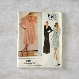 May include: Vintage Vogue American Designers sewing pattern featuring three dress designs. The pattern includes a pink dress with a V-neck and long sleeves, a black floor-length dress, and a light blue dress with a bow detail. The pattern is by Jerry Silverman, pattern number 2674.
