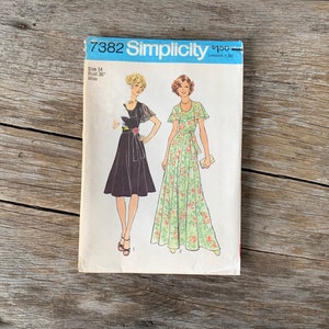May include: Vintage Simplicity sewing pattern number 7382 for a dress. The pattern is for a size 14, bust 36 inches, and is for misses. The pattern shows two different styles of dresses, one black and one floral.