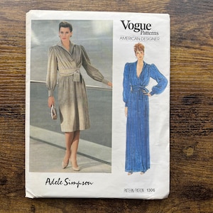 Peut inclure: Patron de couture Vogue Patterns American Designer pour une robe par Adele Simpson. Le numéro du patron est 1306. Le patron montre deux mannequins portant la robe dans des couleurs différentes. Un mannequin porte une robe beige et l'autre porte une robe bleue.