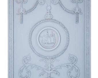 May include: A light blue rectangular panel with an ornate, symmetrical design. The design includes floral and scroll motifs, a central medallion with a ship, and decorative borders. The panel is likely a decorative architectural element.