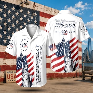 May include: A white short-sleeved button-down shirt featuring a graphic of the Statue of Liberty, the American flag, and the text We the People 1776-2026 with a 250 anniversary emblem. The design includes a small American flag on the sleeve.