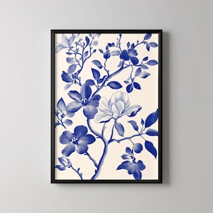 Könnte beinhalten: Gerahmter Kunstdruck mit einer botanischen Illustration. Das Kunstwerk zeigt blaue Blumen und Blätter auf cremefarbenem Hintergrund. Der Druck ist in einem schwarzen Rahmen, ideal für die Inneneinrichtung.