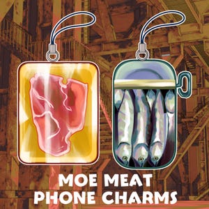 May include: Two phone charms with food-themed designs. One charm features a piece of raw meat in a yellow container, and the other depicts fish in a can. The text "MOE MEAT PHONE CHARMS" is at the bottom.